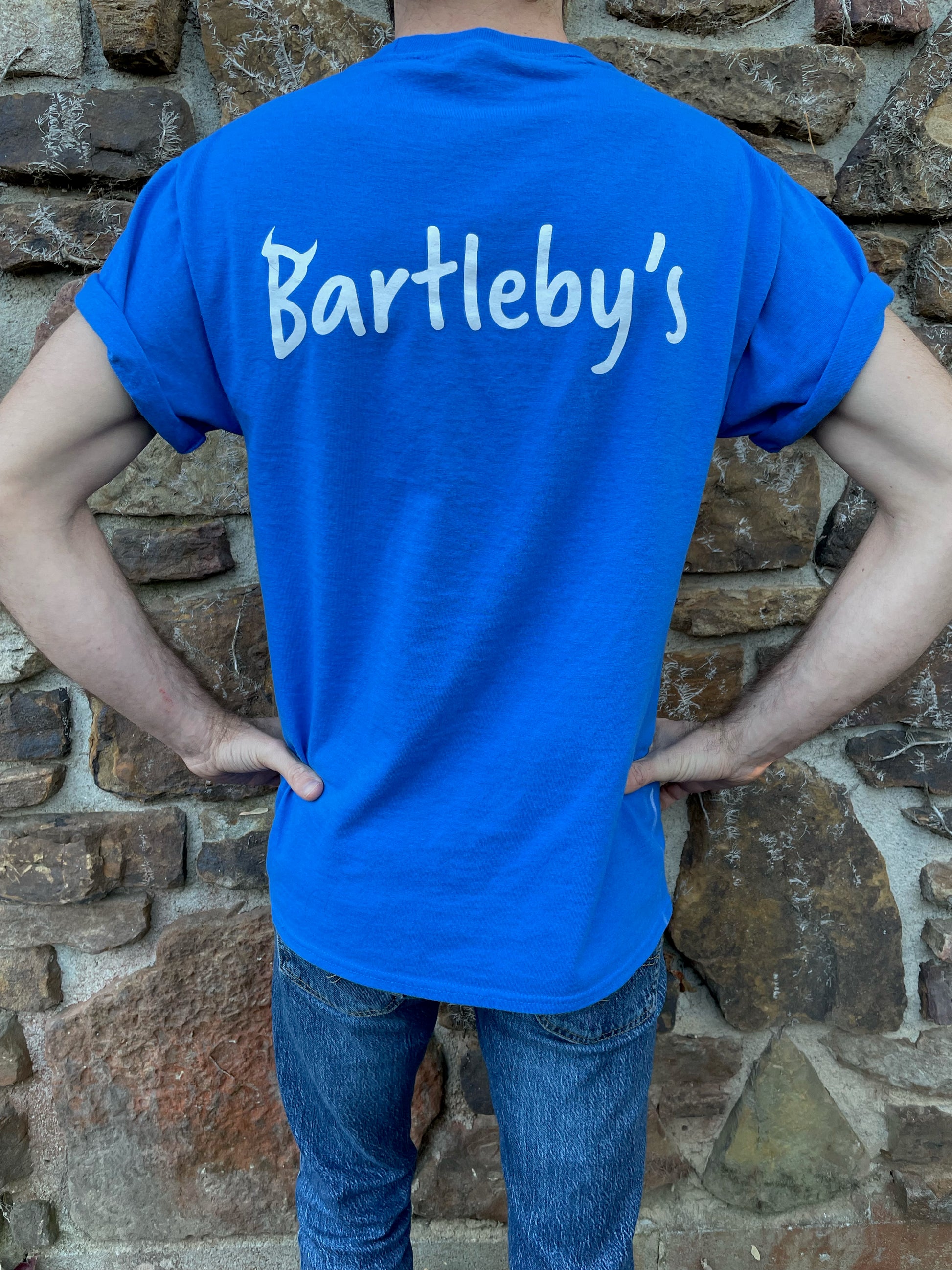 Bring your favorite baby devil, Bartleby, with you where ever you go, tucked in your t-shirt pocket right next to your heart. This blue T-shirt with the devil in the pocket is fun, quirky, and cute, with "Bartleby's" written on the back between the shoulders, allowing you to rep your favorite small woman-owned business. T-shirts ship free!